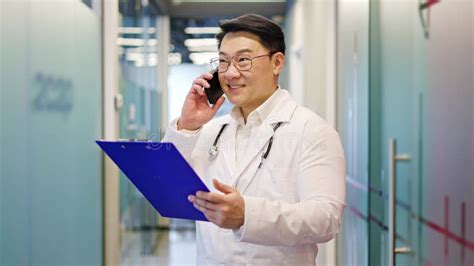 Healthcare Member With Blue Clipboard Having Conversation Over Phone Healthcare Member With Blue Clipboard Having Conversation Over Phone
