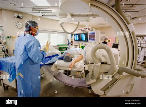 Technician Or Physician Surgeon Performing Angiogram Procedure In Technician Or Physician Surgeon Performing Angiogram Procedure In